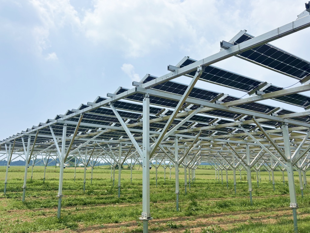 第1期の発電所。高い架台に太陽光パネルを並べ、その下で畑が続いている様子